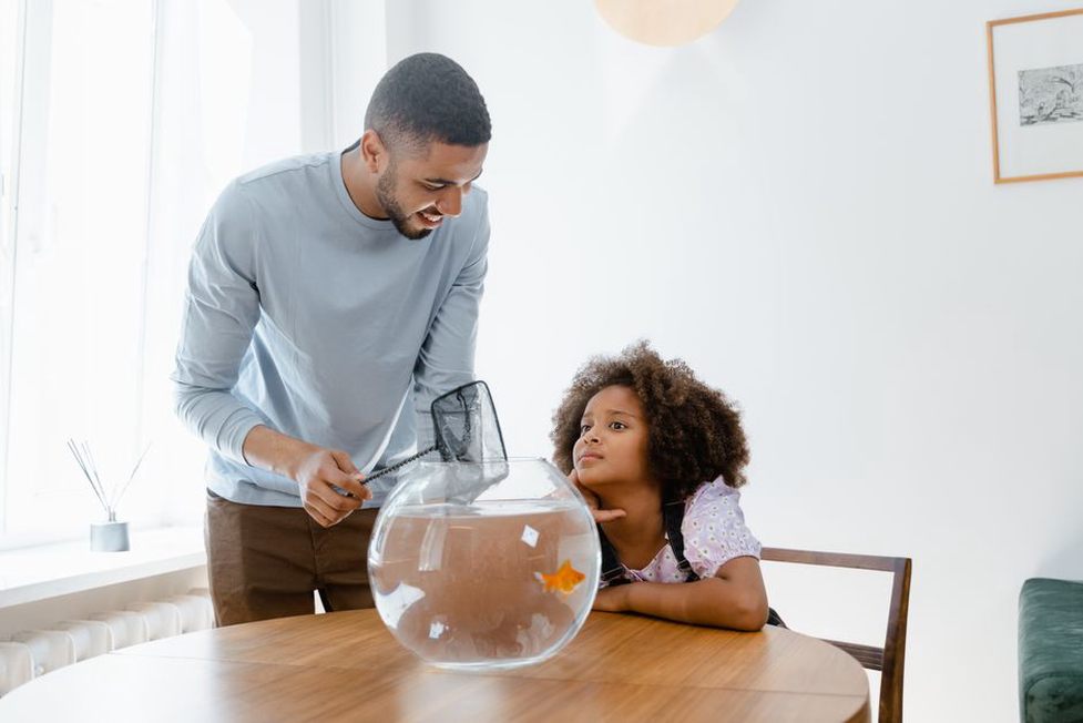Un enfant renouvelle l’eau sous la surveillance d’un adulte