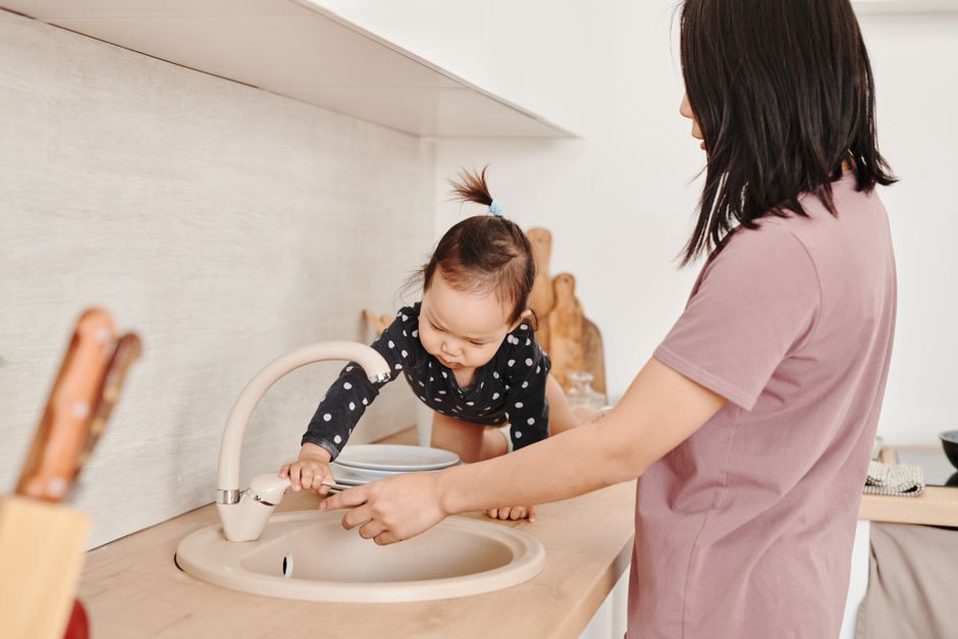 Un enfant remplit la gamelle d’eau sous surveillance