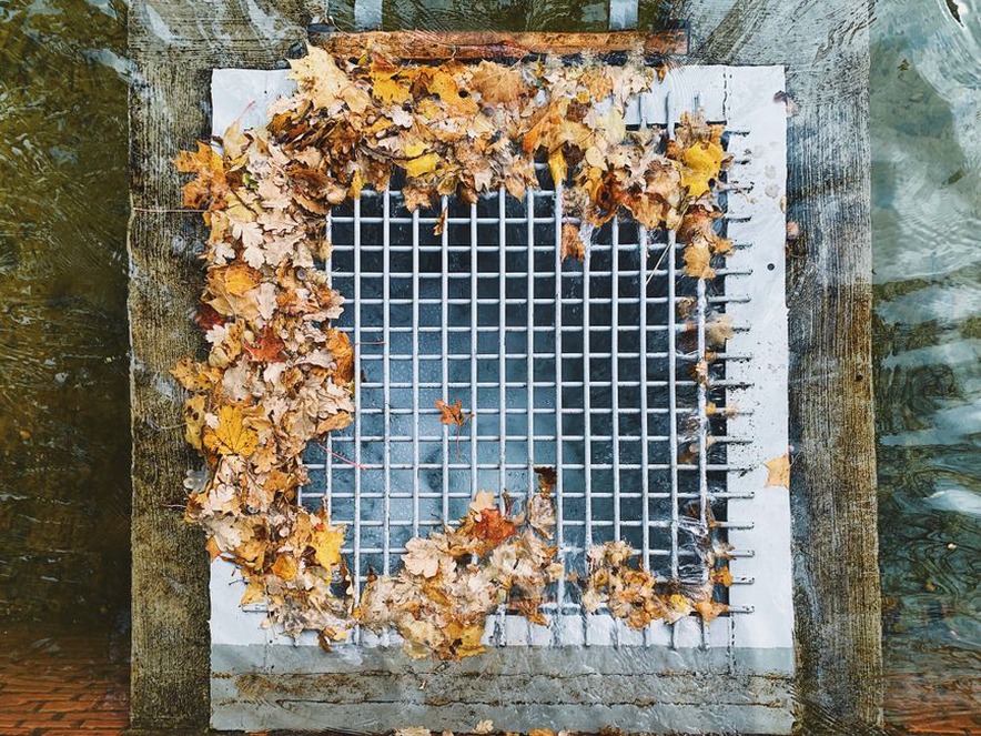 Feuilles accumulées près d’une évacuation extérieure